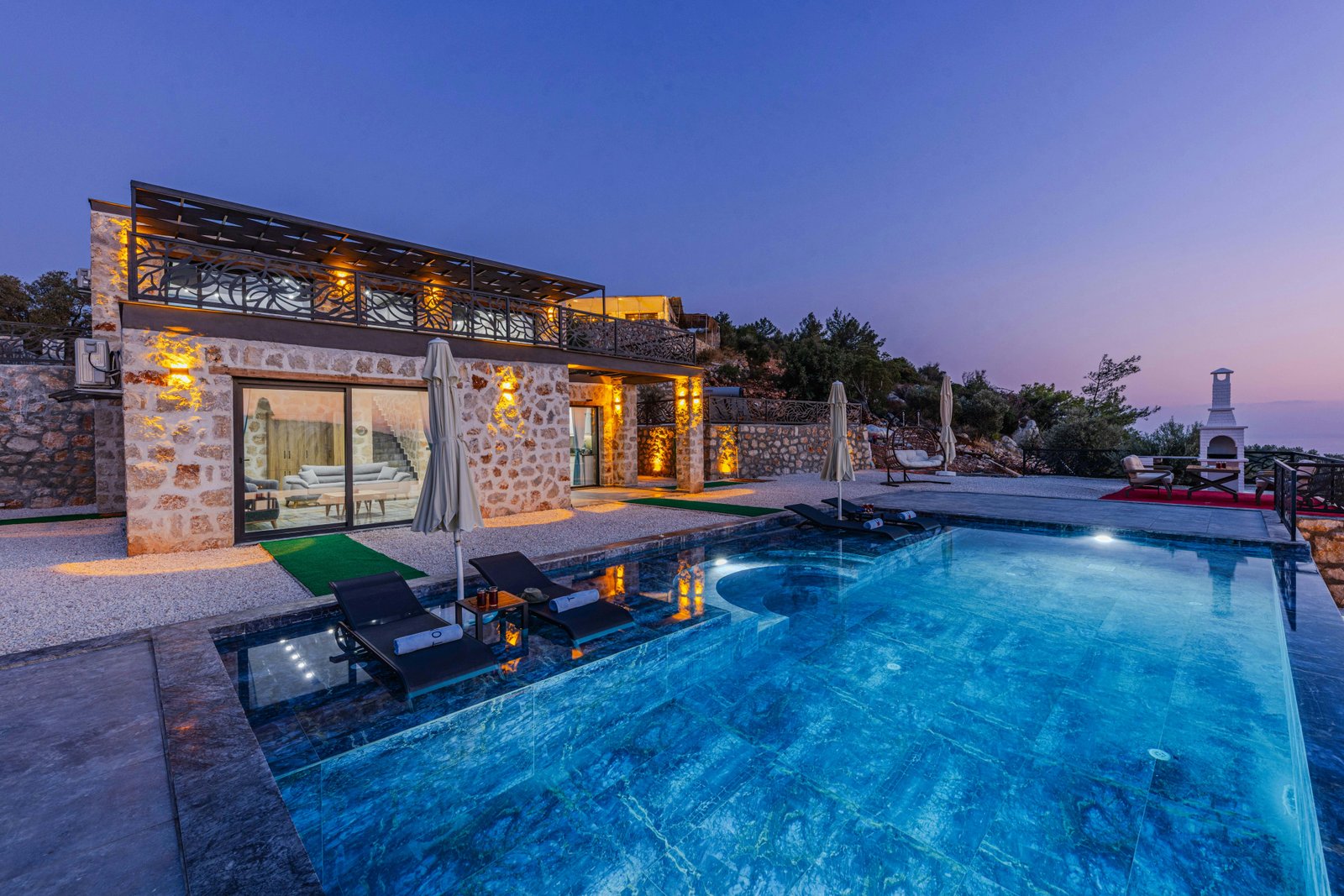 Piscina residenziale di fascia alta con acqua illuminata e villa moderna